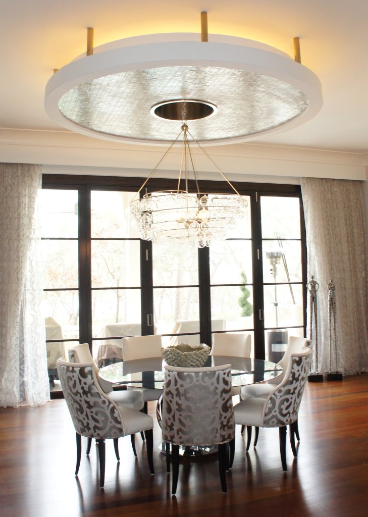 In the Dining area, there is a round disc suspended from stainless bars, with recessed glowing lights.  It appears to hover over our 72" dining table.  The chairs bring in some warmth with its leather seats and gray printed Romo fabric outbacks.  