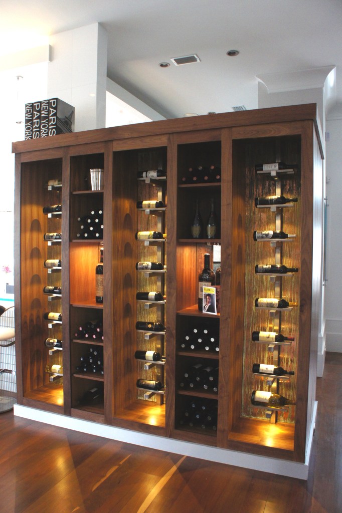 This wine storage and display area was custom designed to serve, not only as functional storage, but also a clever way to separate the Kitchen from the Entry, without feeling closed off.  The warmth of the wood and the accent lights radiates out into the room.