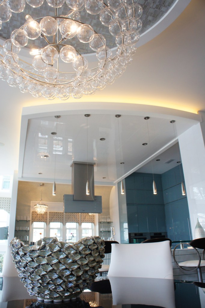 I love this dining chandelier, with its swirling rows of glass balls.  Here you can also see the ceiling treatment we used in the Kitchen.  It is a product called White Ice, which is a man-made version of white thassos granite.  We loved the reflective quality it has, and the way it mirrors the lights from the kitchen windows.  