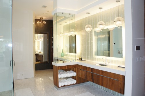 The Vanities consist of custom floating cabinets, shimmering glass "waterafalling" tiles, backlit mirrors, and a floating fireplace!