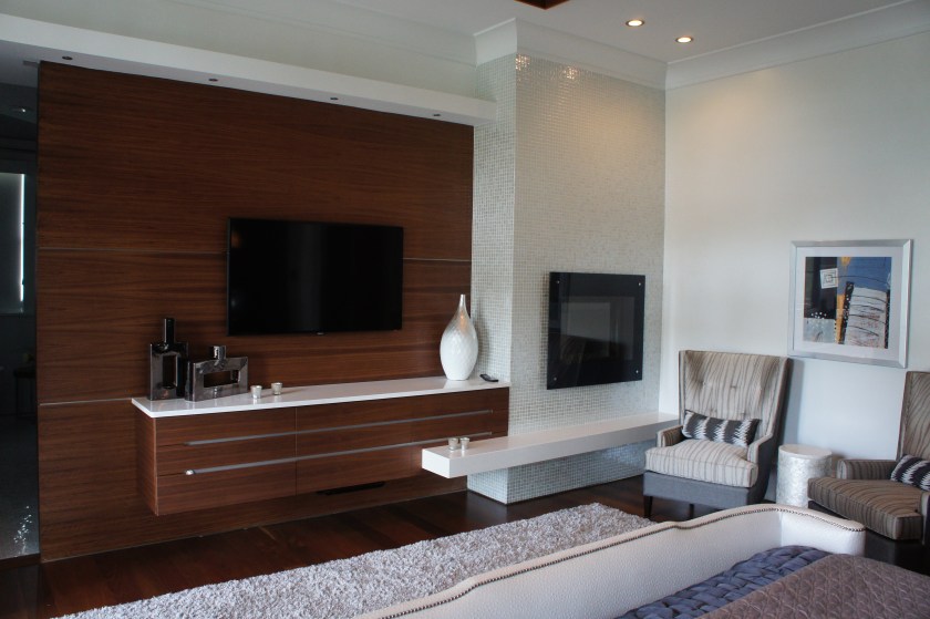 This custom wall design features overlapping lines and planes, a built-in dresser, pearlescent mosaic tile fireplace surround and marble hearth. I love the asymmetry.