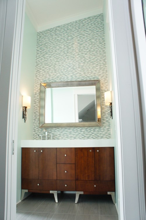 Both girls' rooms have the same bathroom design, except they are mirror images of each other.  The vanity is a furniture piece that we added a thick solid surface top to so that it looked built-in.  We laid the Bliss stone and glass mosaic tiles all along the backsplash, all the way up to the vaulted ceiling.  
