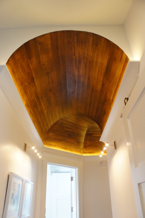 The hallway ceiling on the third floor was a barrel vault, with stained wood for warmth against all the white.  The crown molding hides cove lighting that accents this architectural detail.  This is yet another very cool way the ceilings were shown some "love" on this project!
