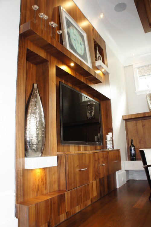 I designed this media wall to be asymmetrical, with mantle, shelves and t.v. console at varying depths.  It is made from quarter sawn maple in a walnut finish.  Instead of trying to make the t.v. the focal point, we succeeded in making that whole area a large sculptural feature.