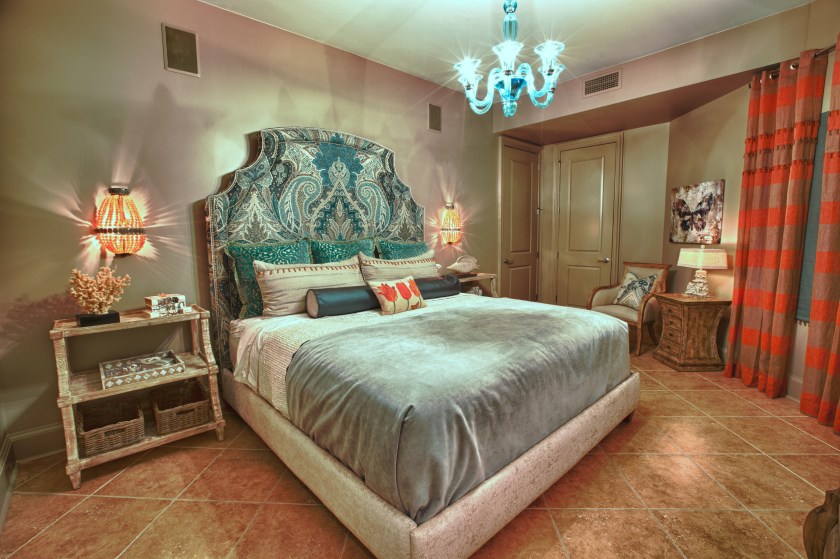 This guest room was furnished with a tall bed, upholstered in a gorgeous Schumacher fabric. Bedside shelves and apricot beaded sconces finish off the bed wall.