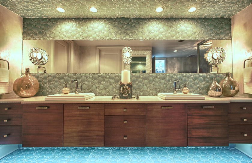 The old cabinetry was removed and replaced with this floating double vanity.  The green glass bubble tiles on the backsplash are divided by one long horizon mirror at eye level.  