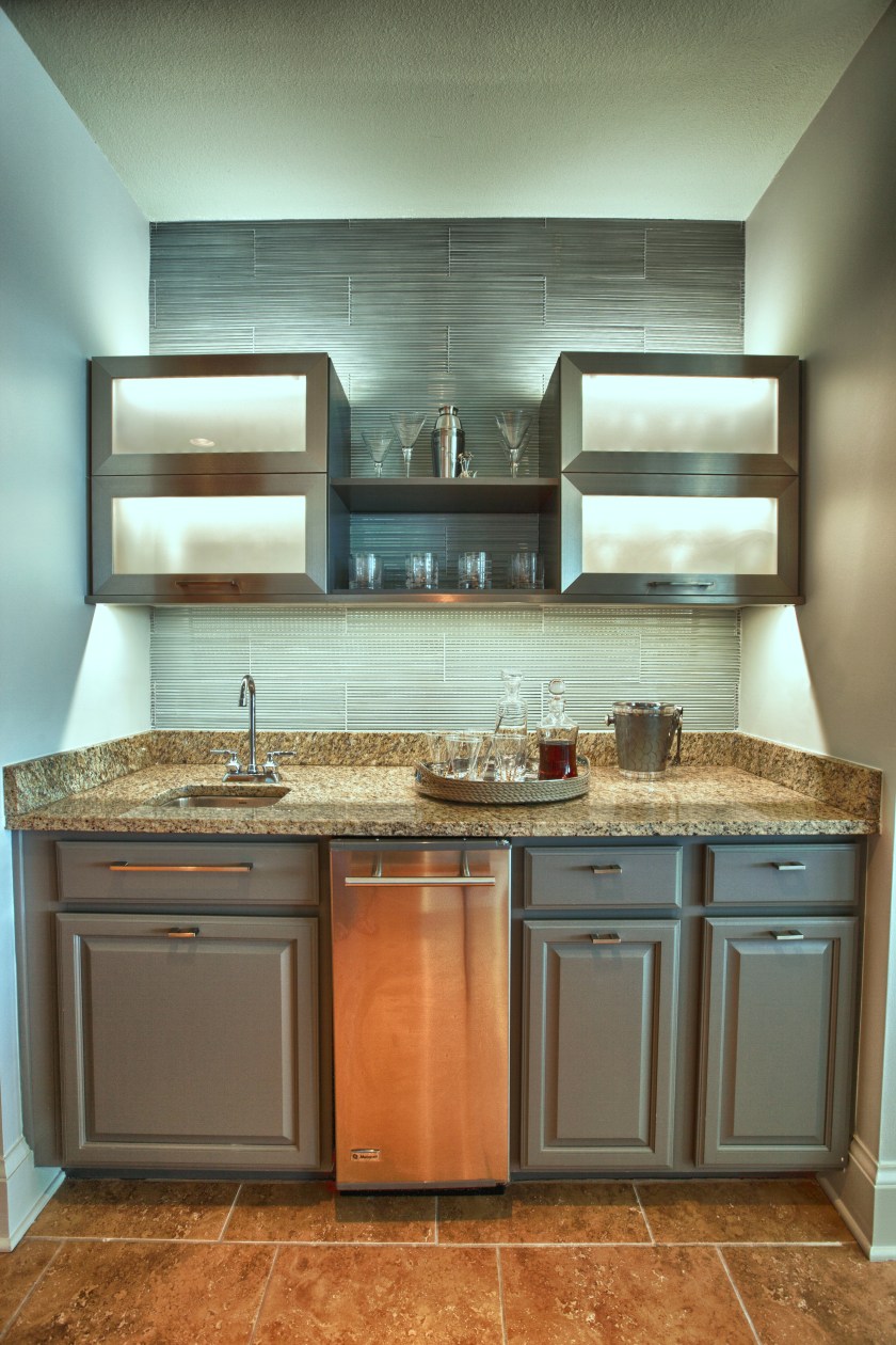 The upper cabinets above the wet bar were removed and replaced with these contemporary stainless steel-framed cabinets and shelves.  The l.e.d. lighting helps to accent the new, fresh tile.