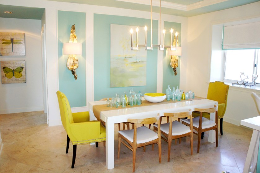 My white lacquer parsons table allowed the vibrant colors around it to stand out.  The dining chairs are raw teak, with white patent vinyl seats.  I covered the host chairs by C.R. Laine in an exciting shade of chartreuse, which was supported in the artwork and bowl centerpiece!