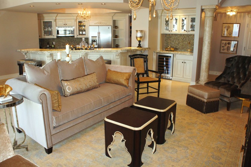The cabinets were finished in a unique pinkish taupe before.  Once the gold walls were not there anymore to reflect off of them, the pink hue stood out even more, so we fauxed them an antique white, with a more neutral base.  The rust marble counters were replaced with a beautiful White Ice granite, with shimmering graphite pieces in it.  The backsplash was replaced with a gold basket weave glass tile.  Instead of doing mirror on the wet bar backsplash, I updated it by adding tile, but installing mirrors behind the cabinet doors.  