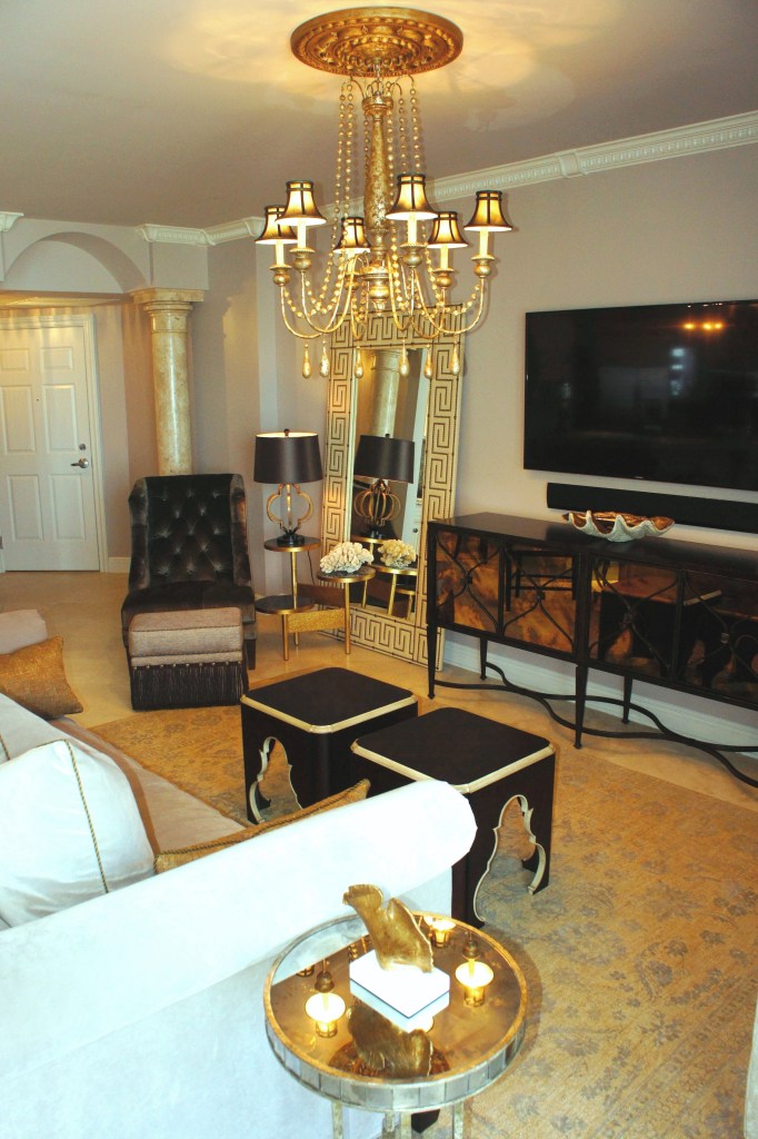 I replaced the chandelier with a larger, more elegant gold wood chandelier, with brown silk shades.  The glass front of the t.v. console has a gold hue of its own, that blends nicely with all the colors.  