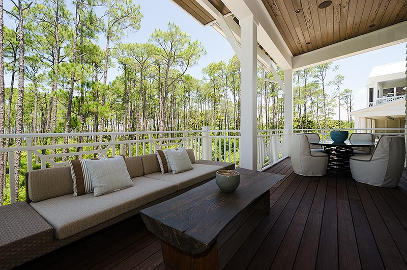 I placed a low, modern sectional by Brown Jordan against the railing. This arrangement utilizes the space the best, without blocking the view of all the gorgeous pines, and western lake. In front of the sofa, is another table made by the builder that I happily utilized!