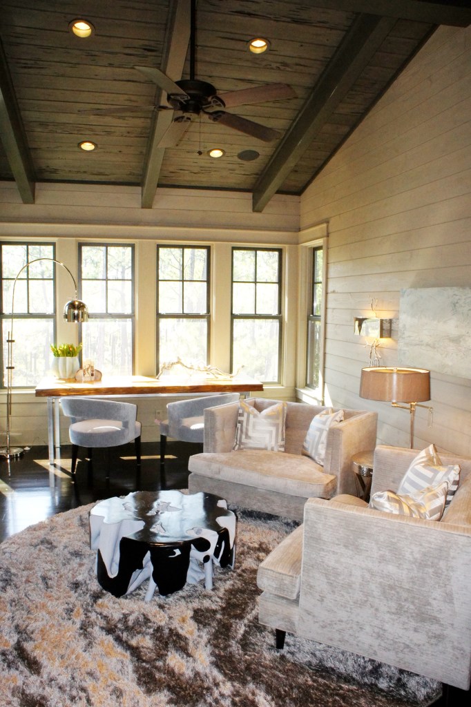 I furnished the main part of this room with a pair of gray chenille chair-and-a-halfs, and round, reflective shag rug and a unique root cocktail table.