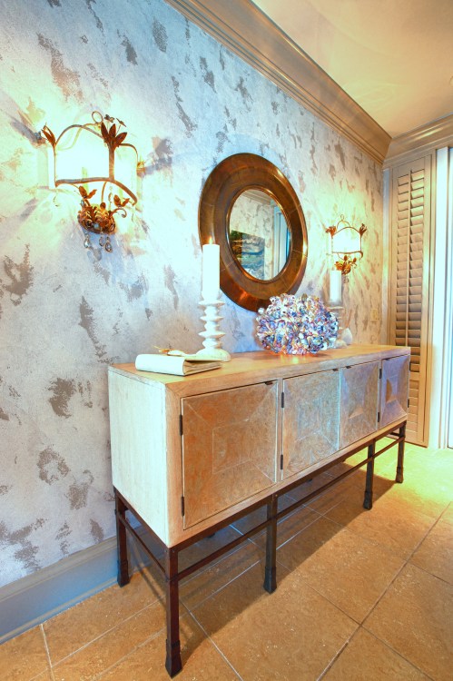 The entry was given a rich, inviting, wall finish that gave the impression  of abstract beach sand.  The handmade oyster lamp, however,  gave this entry some literal coastal flair.  