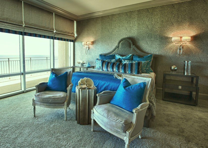 We added plushness with this fabulous new carpeting, new fabric roman shades, and a Kravet wallcovering that I fell in love with! The shape of the headboard works well with all the curvaceous lines in the wall print.