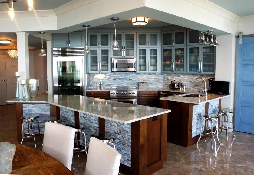 We really opened this kitchen up! The cabinets are two-toned, with a custom-painted blue gray finish on the upper cabinets, and a walnut stain on the bottom.  I tied all the colors in the room together with this glass tile backsplash!  