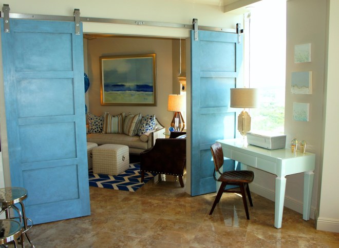 These custom barn doors, leading to the Den, add a touch of modern, and a touch of coastal charm! I  had them finished in the same powder blue as the entertainment console in the Living Room.  