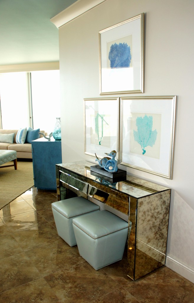 This angled wall was the perfect spot for a multi-functional mirrored console.  It can be used as a server for the dining area, but I added the stools so that there was extra seating during a meal or a place to sit and do work. The ottomans can be easily utilized in the Living Room as auxiliary seating for kids!