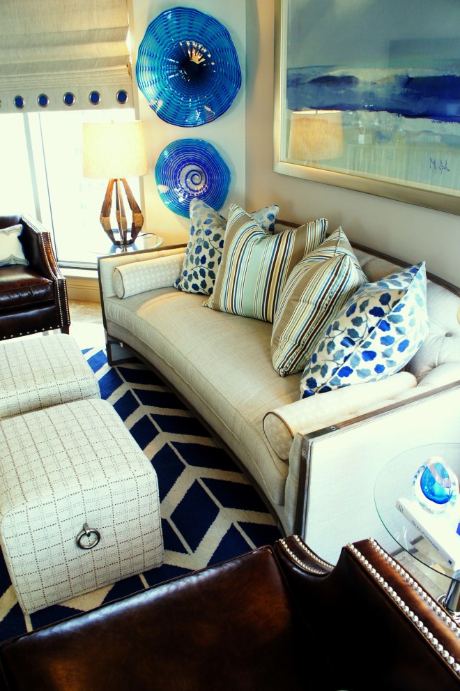 The brown leather and polished nickel nail heads on the club chairs counterbalance the brown wood and polished nickel brackets on the settee!