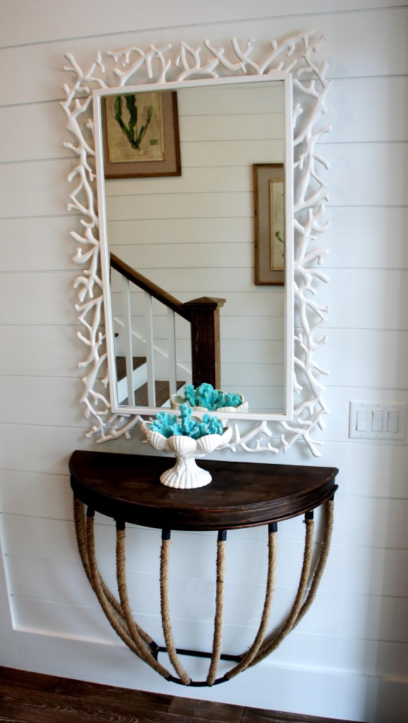 Floating rope console and coral mirror set the tone for the rest of the house: Casual, whimsical, bright and fun.